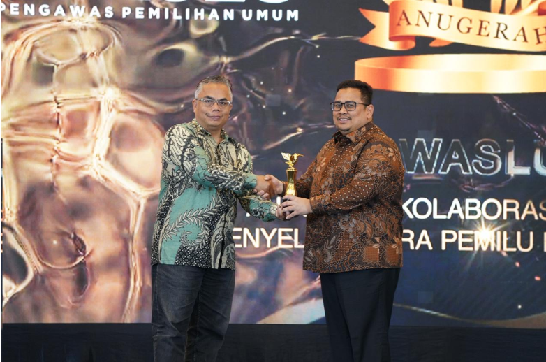 Ketua Bawaslu Rahmat Bagja menerima penghargaan Anugerah Kolaborasi Strategis Penyelenggara Pemilu bersama Media yang diserahkan oleh Wakil Pemred INDOPOSCO Folber Siallaga di Jakarta, Selasa (3/2/2026).
