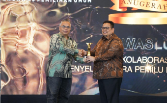 Ketua Bawaslu Rahmat Bagja menerima penghargaan Anugerah Kolaborasi Strategis Penyelenggara Pemilu bersama Media yang diserahkan oleh Wakil Pemred INDOPOSCO Folber Siallaga di Jakarta, Selasa (3/2/2026).